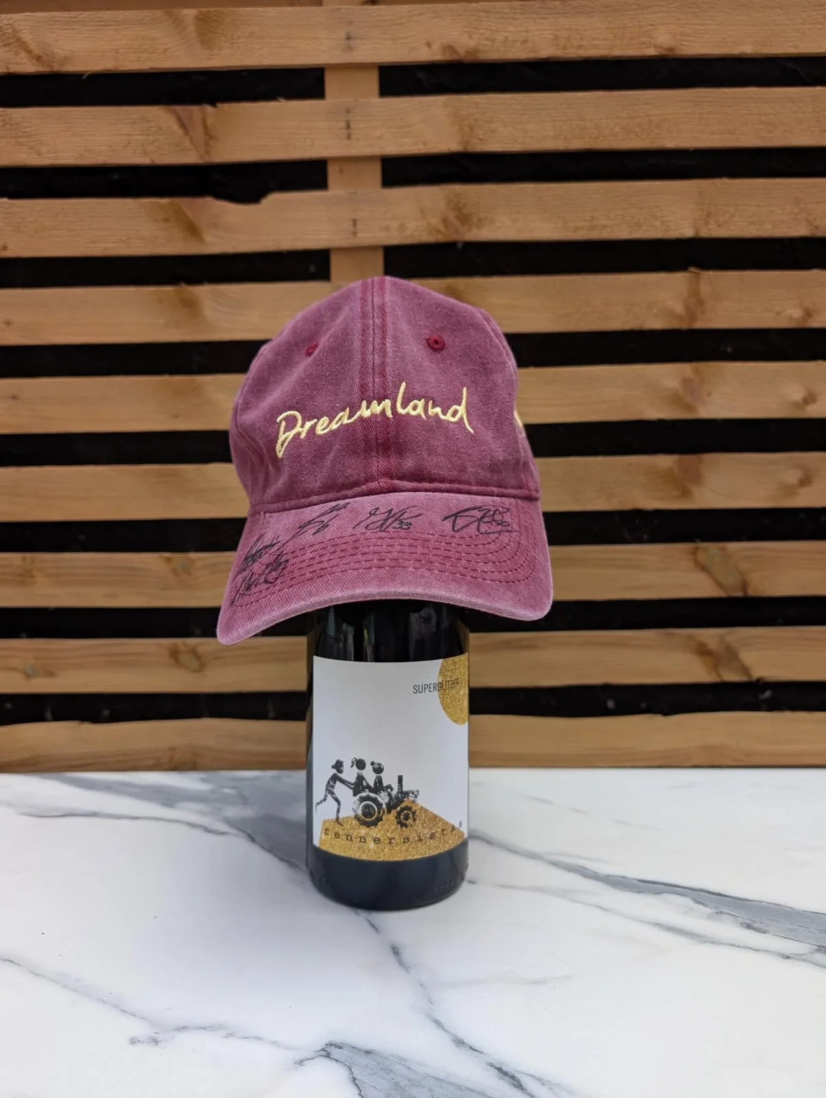 Dreamland Cafe dad hat in maroon with gold embroidery, signed by PWHL Ottawa CHARGE players along the brim